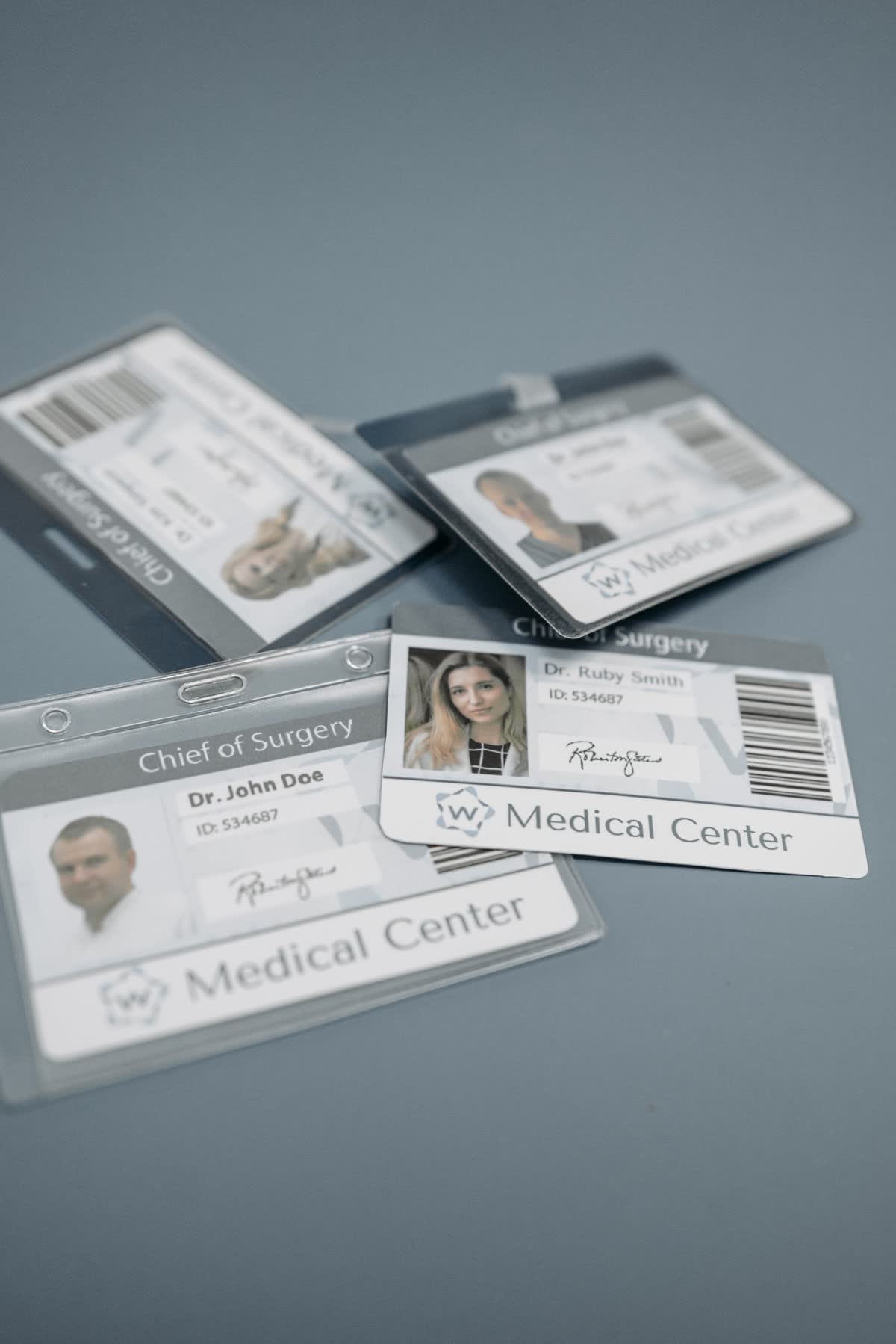 Several identity cards with photographs lying on a grey surface